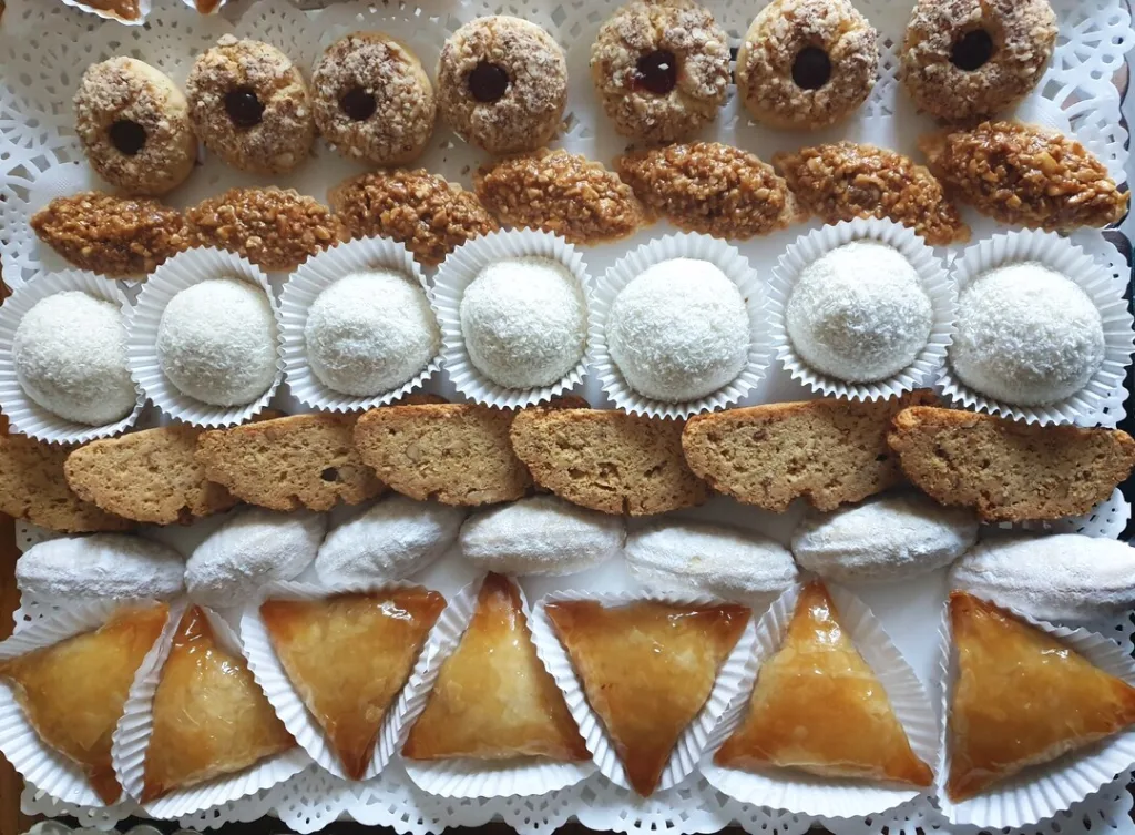 Een blad met verschillende soorten koekjes waaronder briwat koekjes (in de vorm van een driehoek).